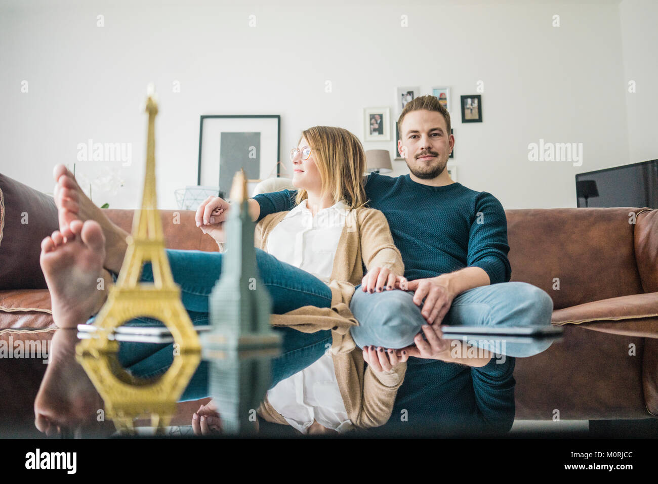 Paar auf der Couch zu Hause sitzen und das Modell der Eiffelturm und das Empire State Building Stockfoto