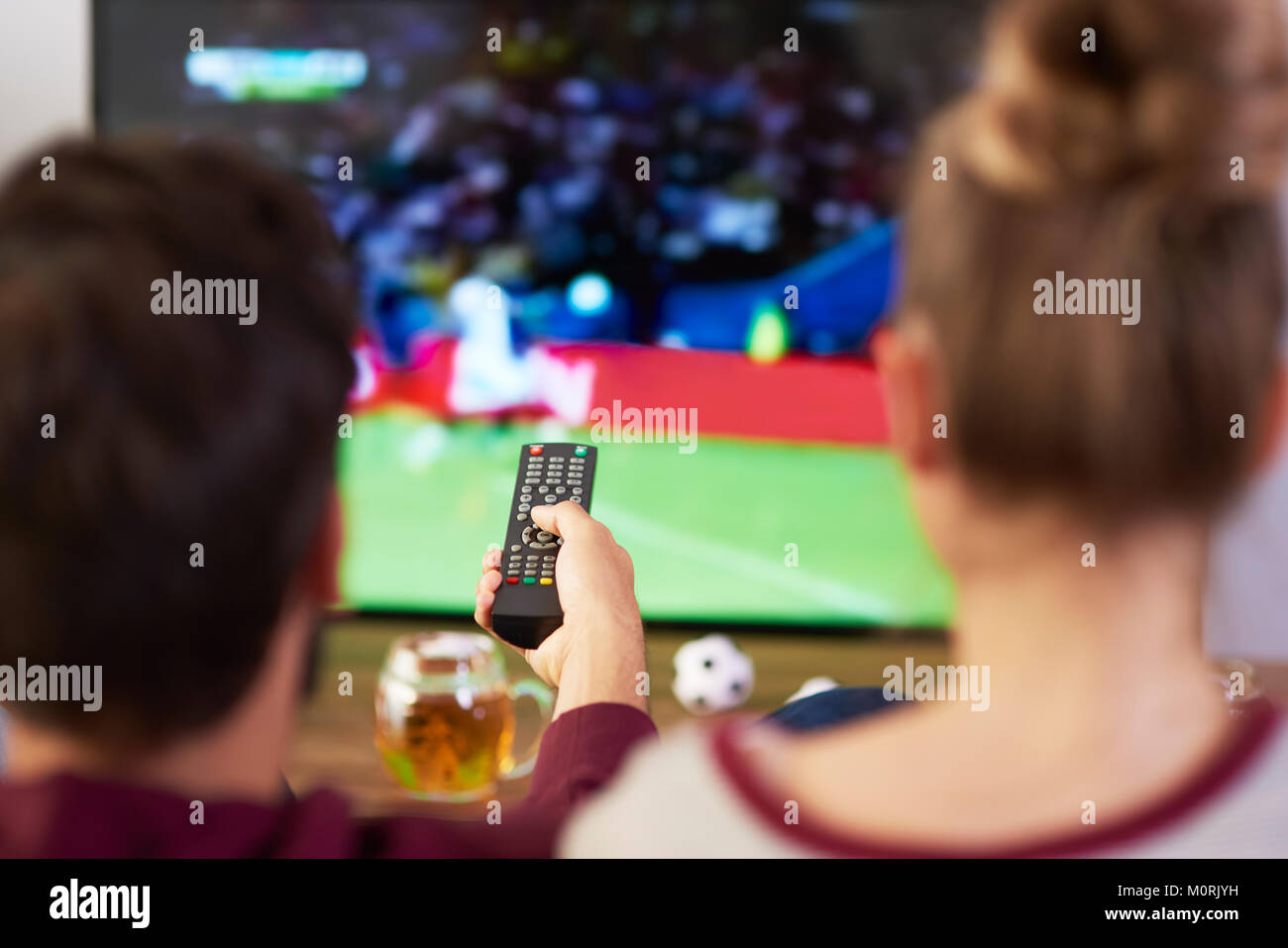 Paar beobachten Fußballspiel im Fernsehen Stockfoto