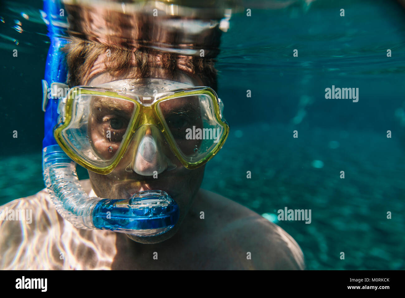 Porträt eines Mannes mit Taucherbrille und Schnorchel unter Wasser in einem Pool Stockfoto