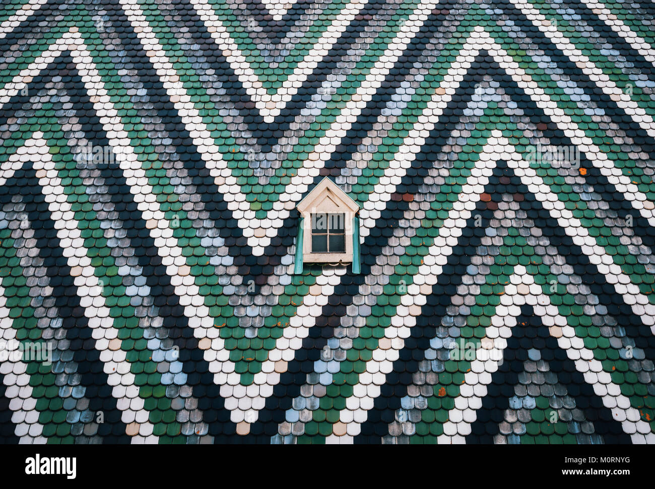 Kleines Fenster auf an die Wand gemalt mit blauen, grünen und weißen Streifen im Zickzack. Stephansdom, Wien, Österreich. Minimalismus Konzept Stockfoto