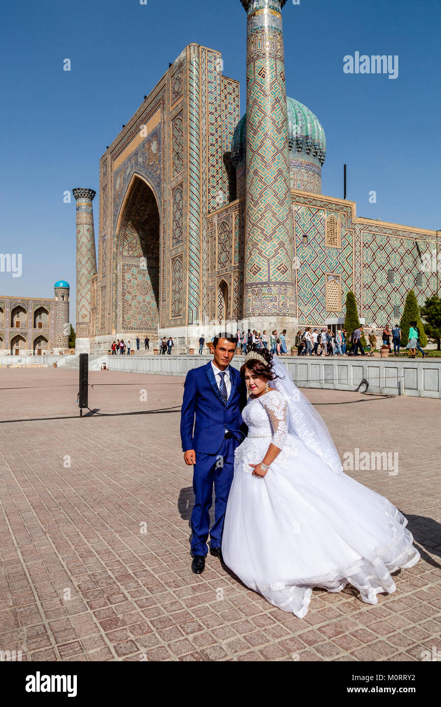 Eine 'Just Married' junge Paar posieren für ein Foto bei der registan Komplexes, Samarkand, Usbekistan Stockfoto