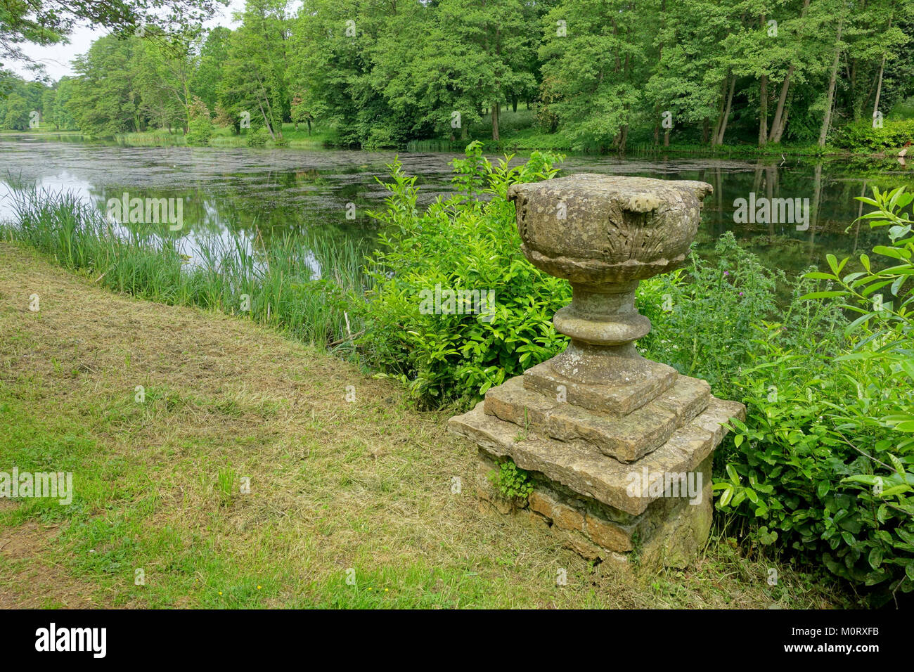 Die Cascade und die künstlichen Ruinen in Stowe, Buckinghamshire, sind Landschaftsbilder aus dem 18. Jahrhundert, die von Capability Brown entworfen wurden. Die Kaskade verbindet den Octagon Lake mit dem Eleven Acre Lake, wobei Wasser über eine Reihe von Bögen fließt. Die künstlichen Ruinen, die in den 1730er Jahren gebaut wurden, sollen so aussehen, als wären sie alte Überreste. Stockfoto
