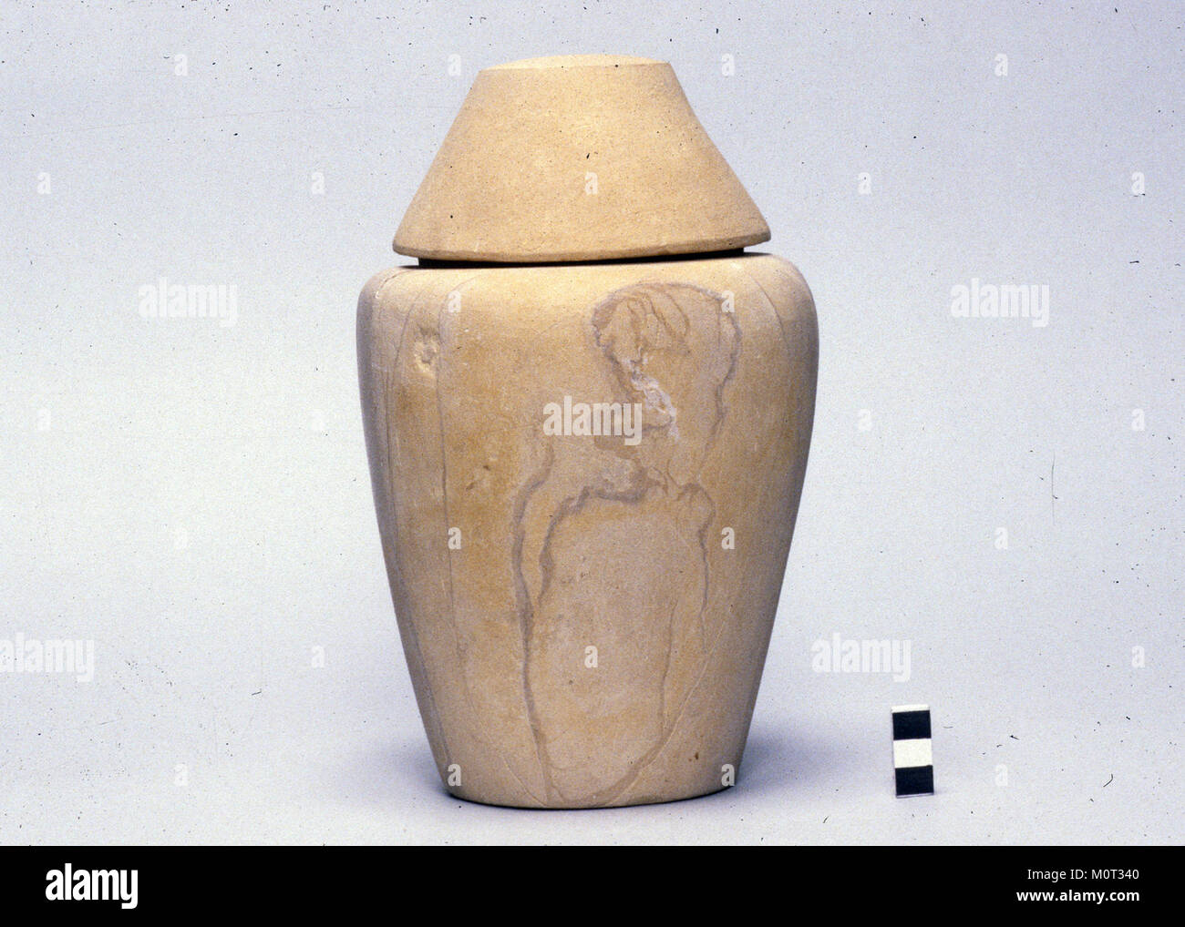 Dieses Kanopenglas mit konischem Deckel ist ein altägyptisches Artefakt, das bei Begräbnispraktiken verwendet wird. Das Gefäß wurde entworfen, um innere Organe des Verstorbenen zu lagern und ist ein Beispiel für ägyptische Grabkunst. Stockfoto