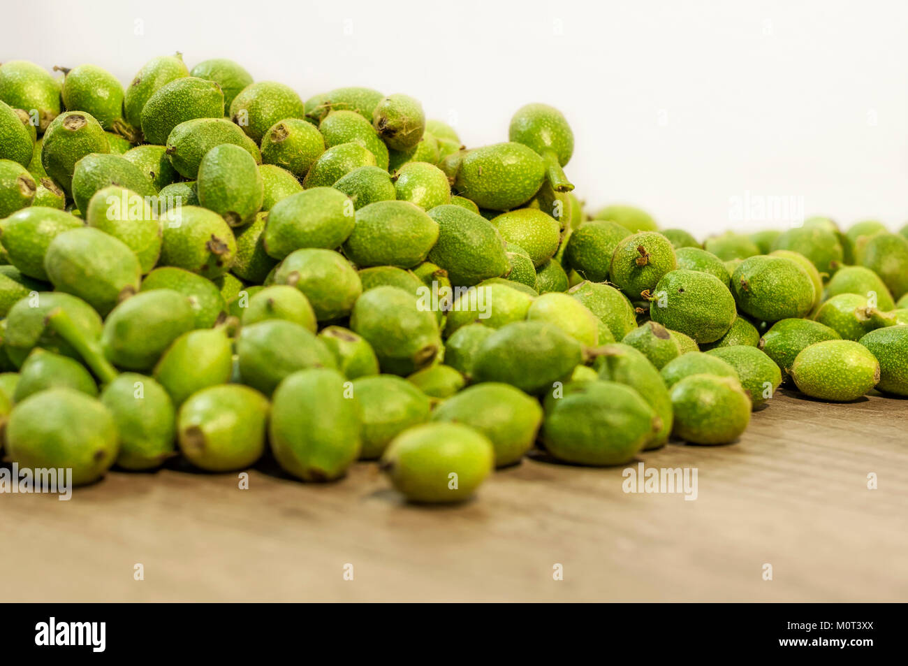 Viel Grün junge Walnüsse in Schalen auf hölzernen Tisch Stockfoto