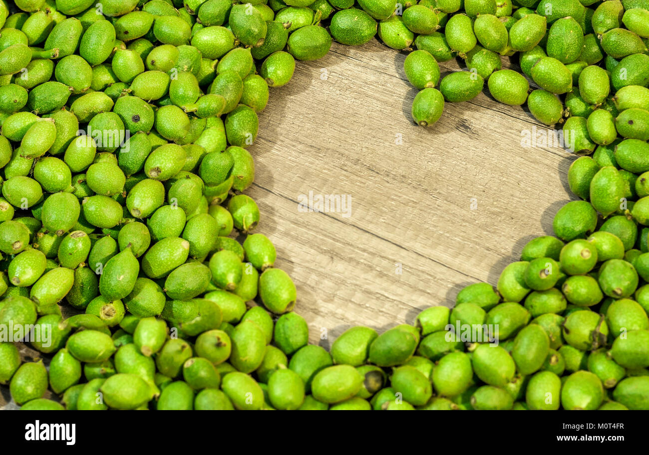 Viel Grün junge Walnüsse in Schalen auf dem Tisch in der Form des Herzens Stockfoto