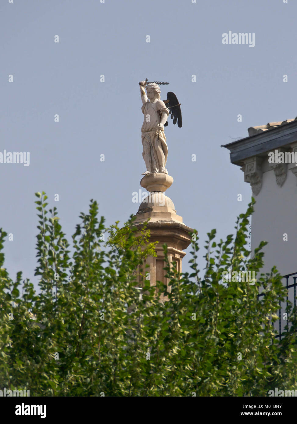 Ein Foto der Kathedrale von Granada, Spanien, mit einer Skulptur eines Engels. Die Kathedrale ist bekannt für ihre atemberaubende Renaissance- und Barockarchitektur, die sie zu einem wichtigen religiösen und kulturellen Wahrzeichen macht. Stockfoto