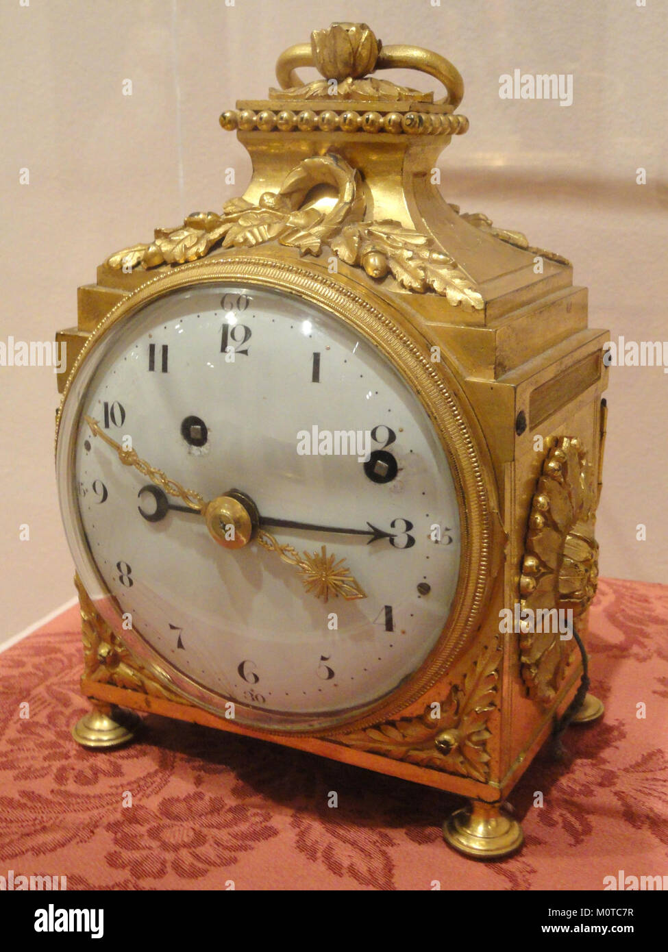 Diese französische Kutschenuhr aus dem 18. Jahrhundert, die von einem unbekannten Künstler gefertigt wurde, ist aus Bronze dore, einem vergoldeten Metall, das häufig für Uhrengehäuse verwendet wird. Das Stück befindet sich im Museum of Fine Arts in Springfield, Massachusetts. Es repräsentiert die Präzision und Handwerkskunst der französischen Uhrmacherei während dieser Zeit und bietet Einblick in dekorative und funktionale Designelemente der Zeit. Stockfoto