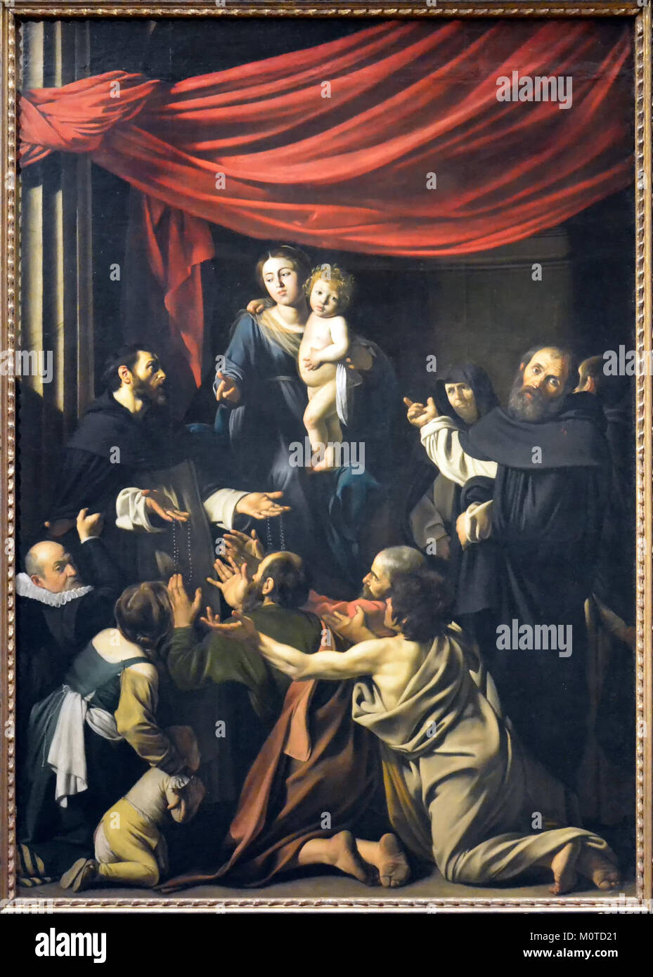 Die Rosenkranzmadonna von Caravaggio ist ein bedeutendes barockes Gemälde, das für seine dramatische Verwendung von Licht und Schatten bekannt ist und die Jungfrau Maria mit dem Christkind in einem religiösen Kontext darstellt. Stockfoto