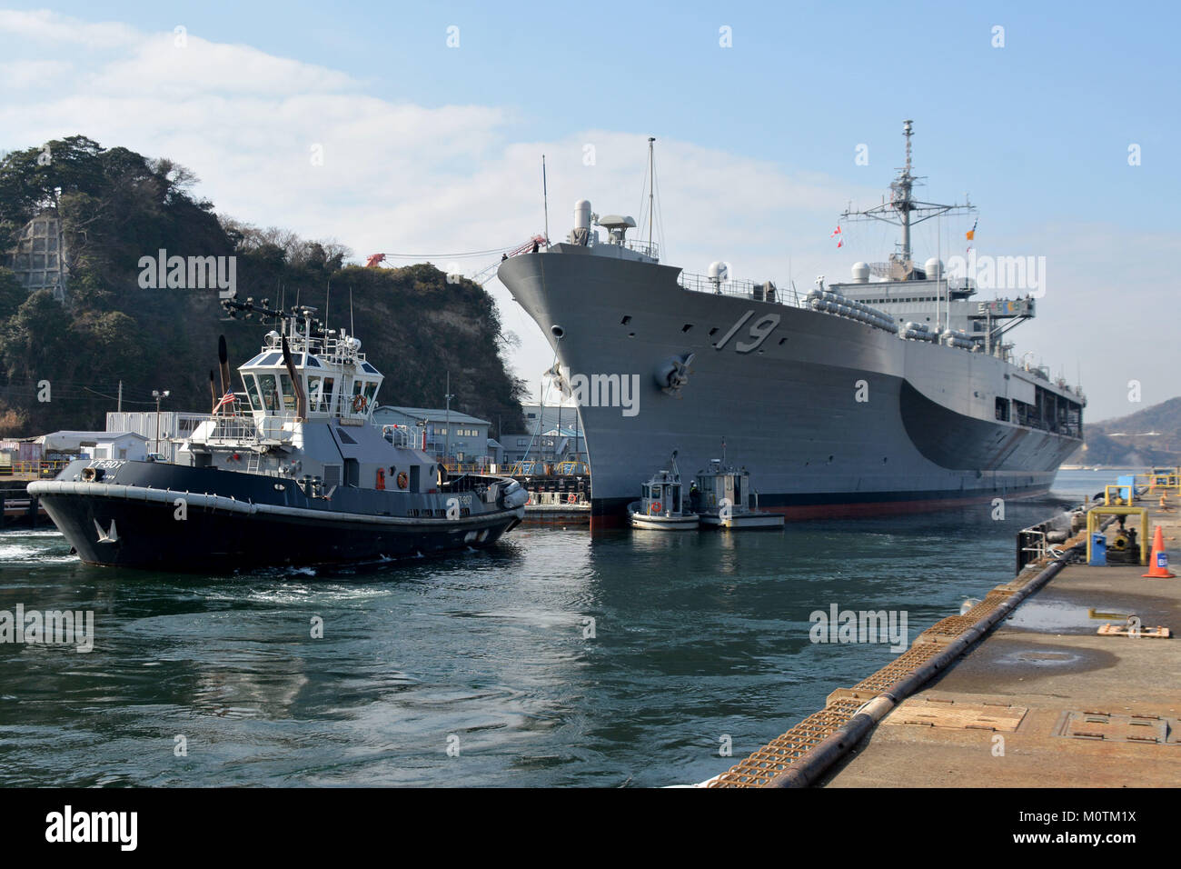 Die Valiant-Klasse Hof tugboat Menominee (YT807) unterstützt die USA 7 Flotte Flaggschiff USS Blue Ridge (LCC 19) lassen Sie Dry Dock6 an der Flotte Aktivitäten (FLEACT) Kamakura. Stockfoto