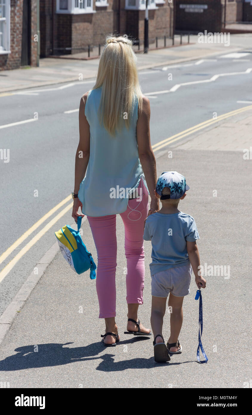 Junge Mutter und Kind wandern in Street, High Street, Battle, East Sussex, England, Vereinigtes Königreich Stockfoto