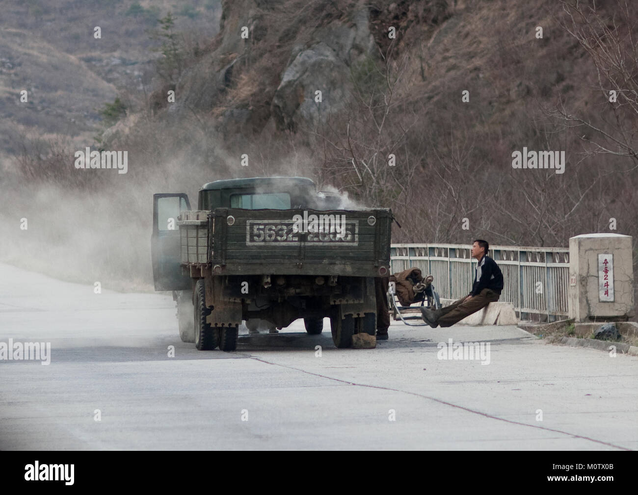 Die nordkoreanischen Männer Reparieren einer rauchen Dampf Lkw auf der Autobahn, Kangwon Provinz, Wonsan, Nordkorea Stockfoto
