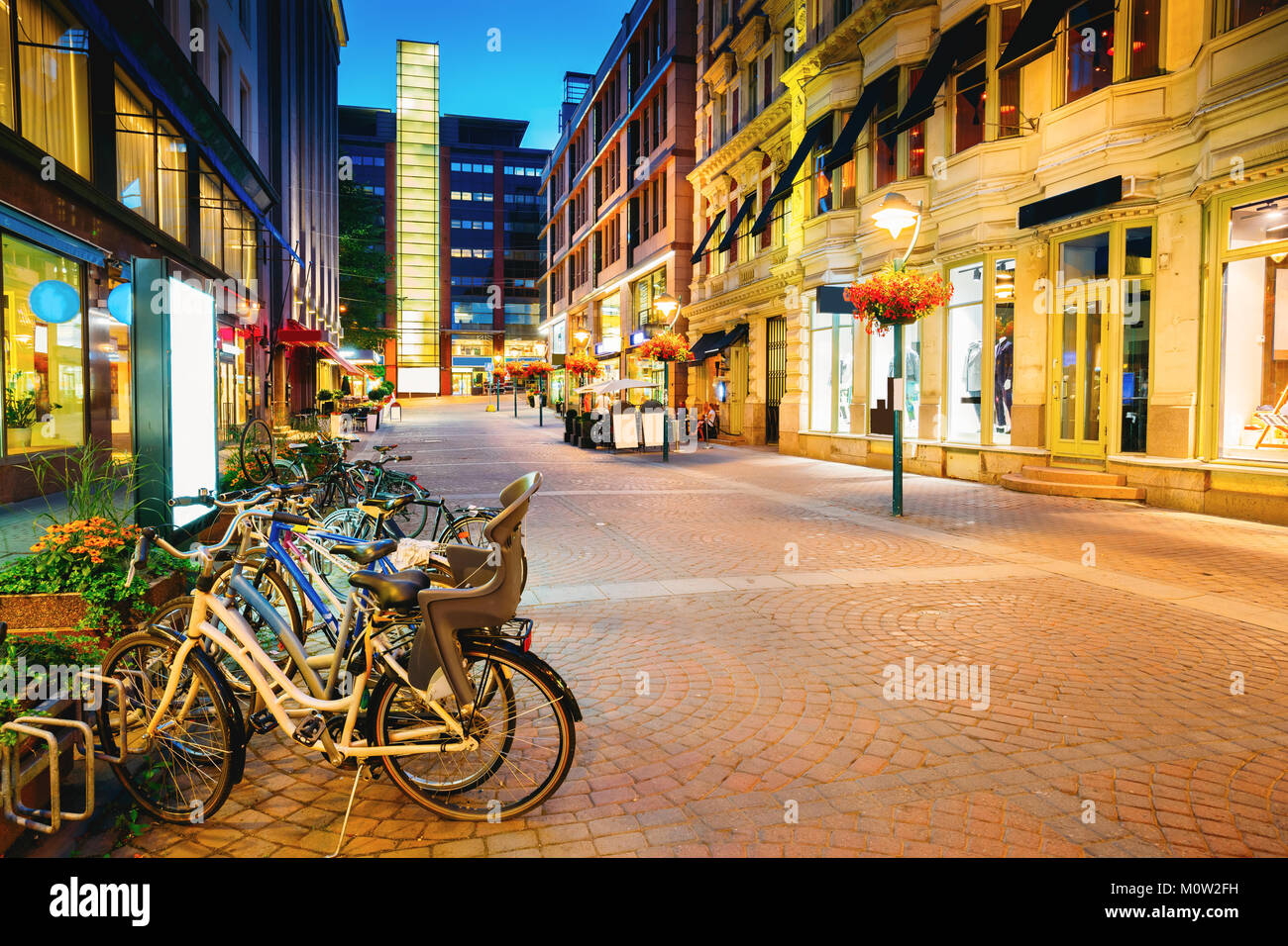 Helsinki, Finnland. Fahrräder in der Nähe von Läden in Kluuvikatu Straße geparkt. Nacht Kluuvikatu Straße in Kluuvi erhalten Bezirk am Abend oder in der Nacht, beleuchtet Stockfoto