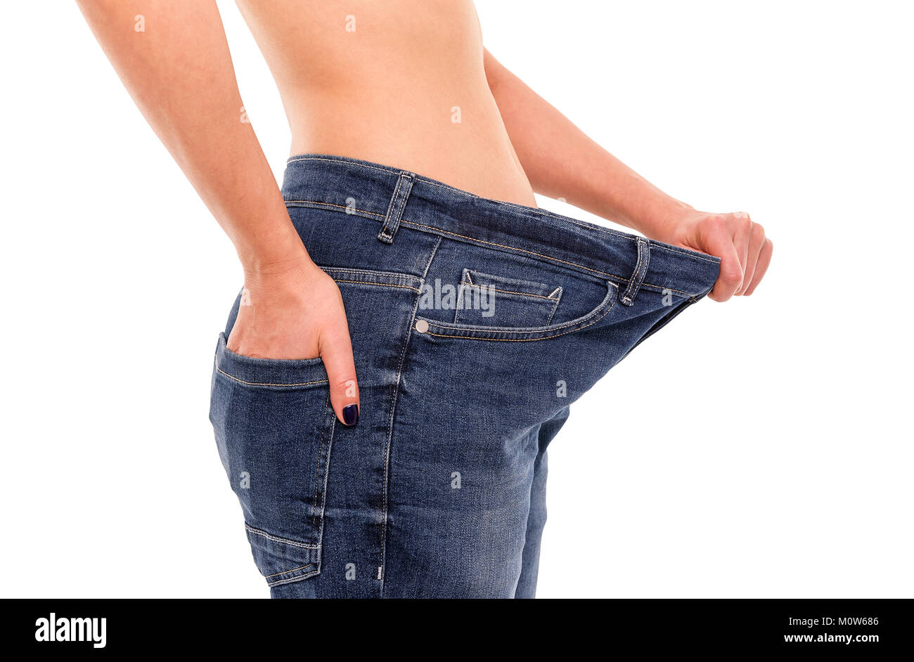 Frau zeigt, dass Sie Gewicht verloren hat. Big Jeans. Stockfoto