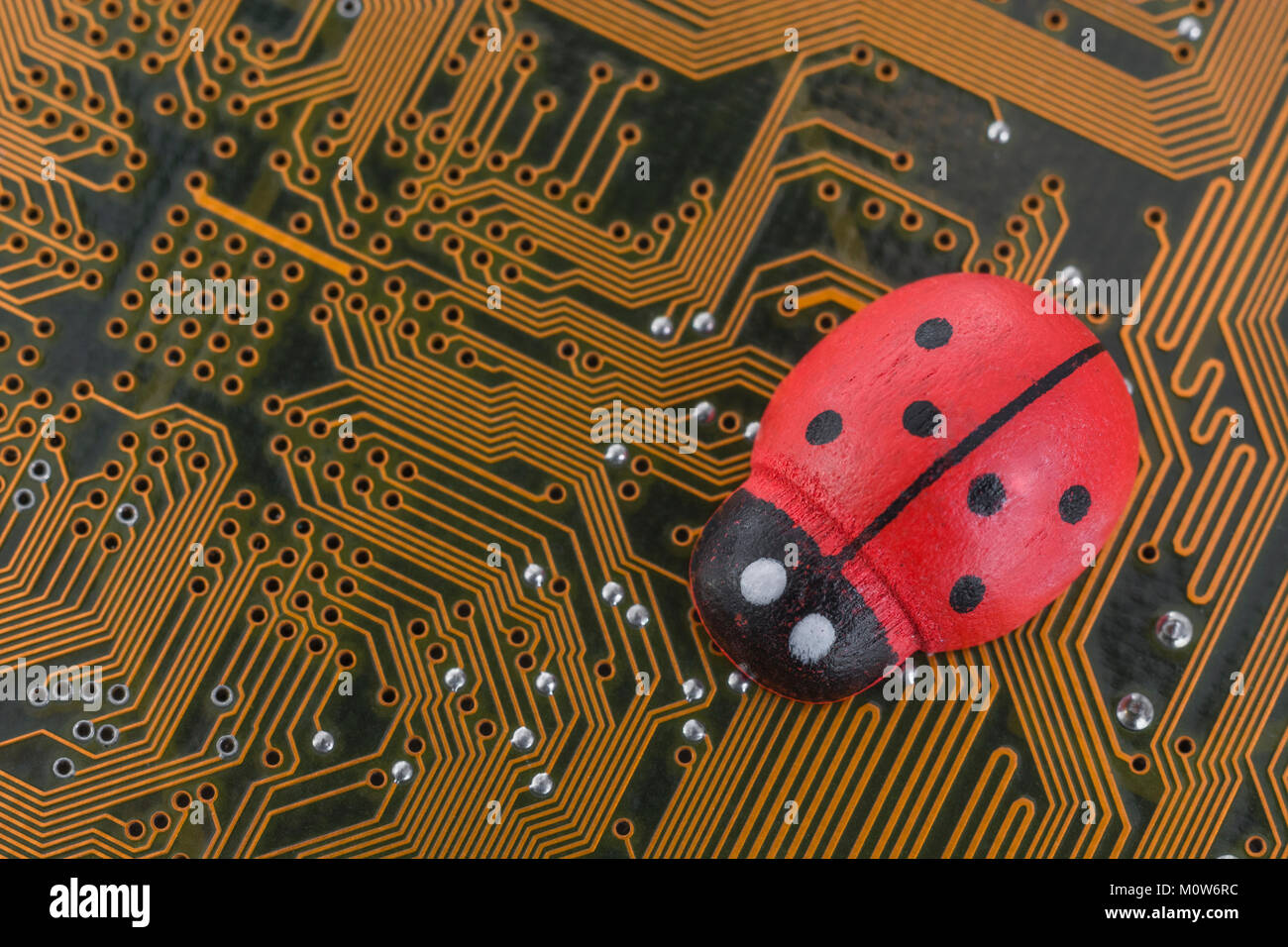 Kleines Spielzeug Marienkäfer - als visuelle Metapher für das Konzept der Computer bugs, Bugs, Bugs, Viren. Stockfoto