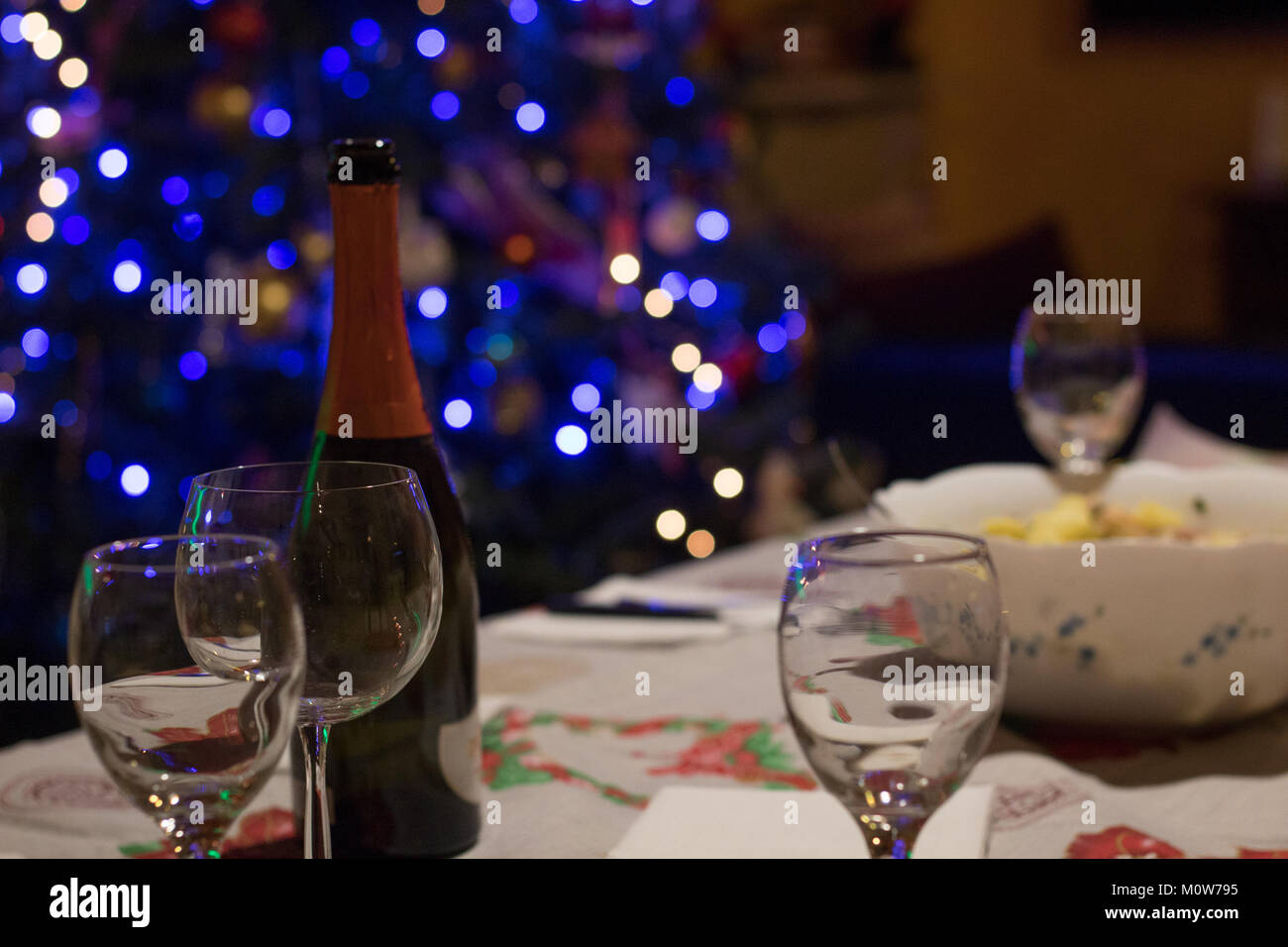 Gläser und Flasche Wein auf Tisch mit Weihnachtsbaum hinter, flacher konzentrieren. Stockfoto