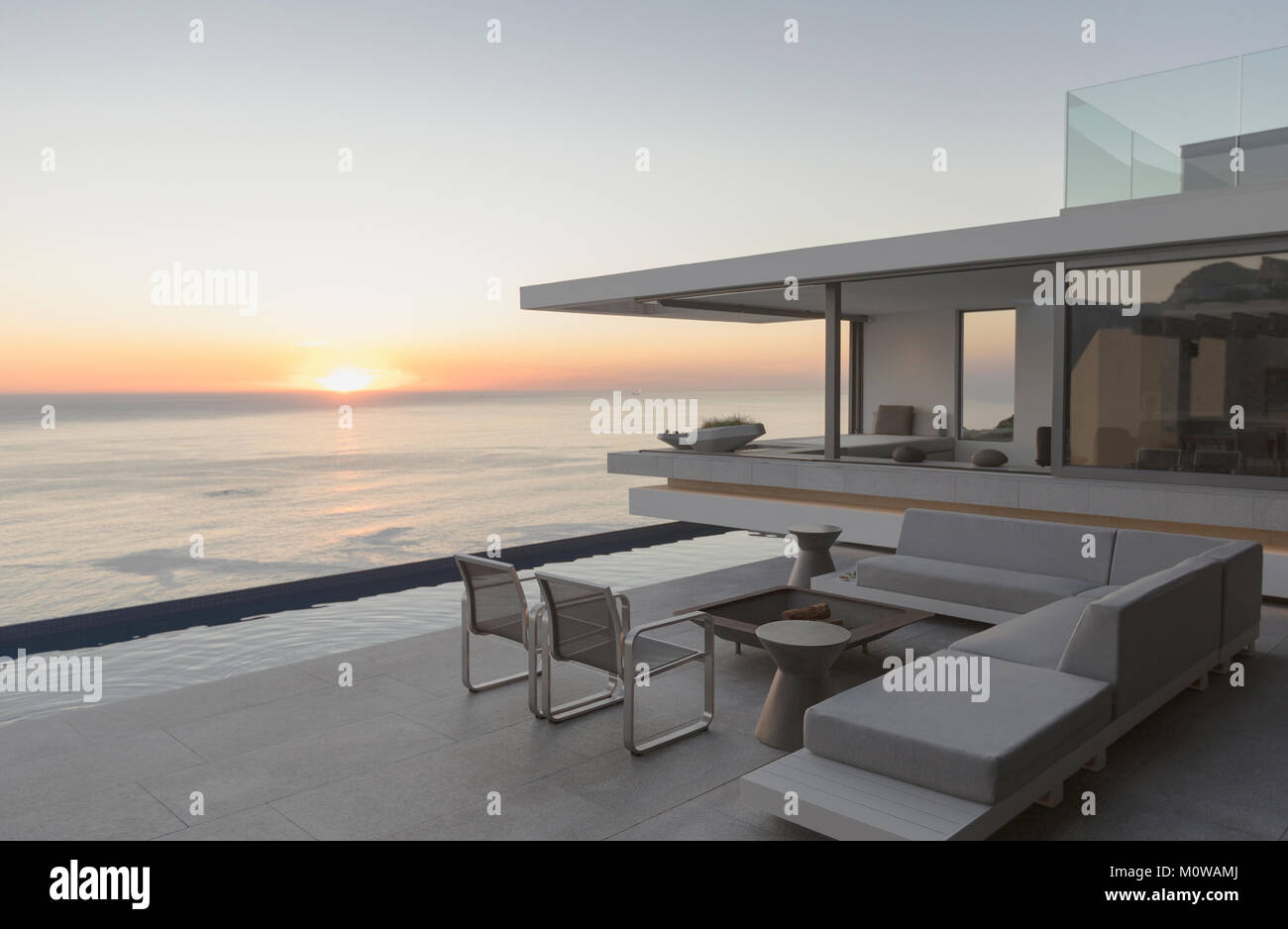 Blick auf den Sonnenuntergang über dem Meer Horizont von Moderne und luxuriöse Home Showcase äußere Terrasse Stockfoto