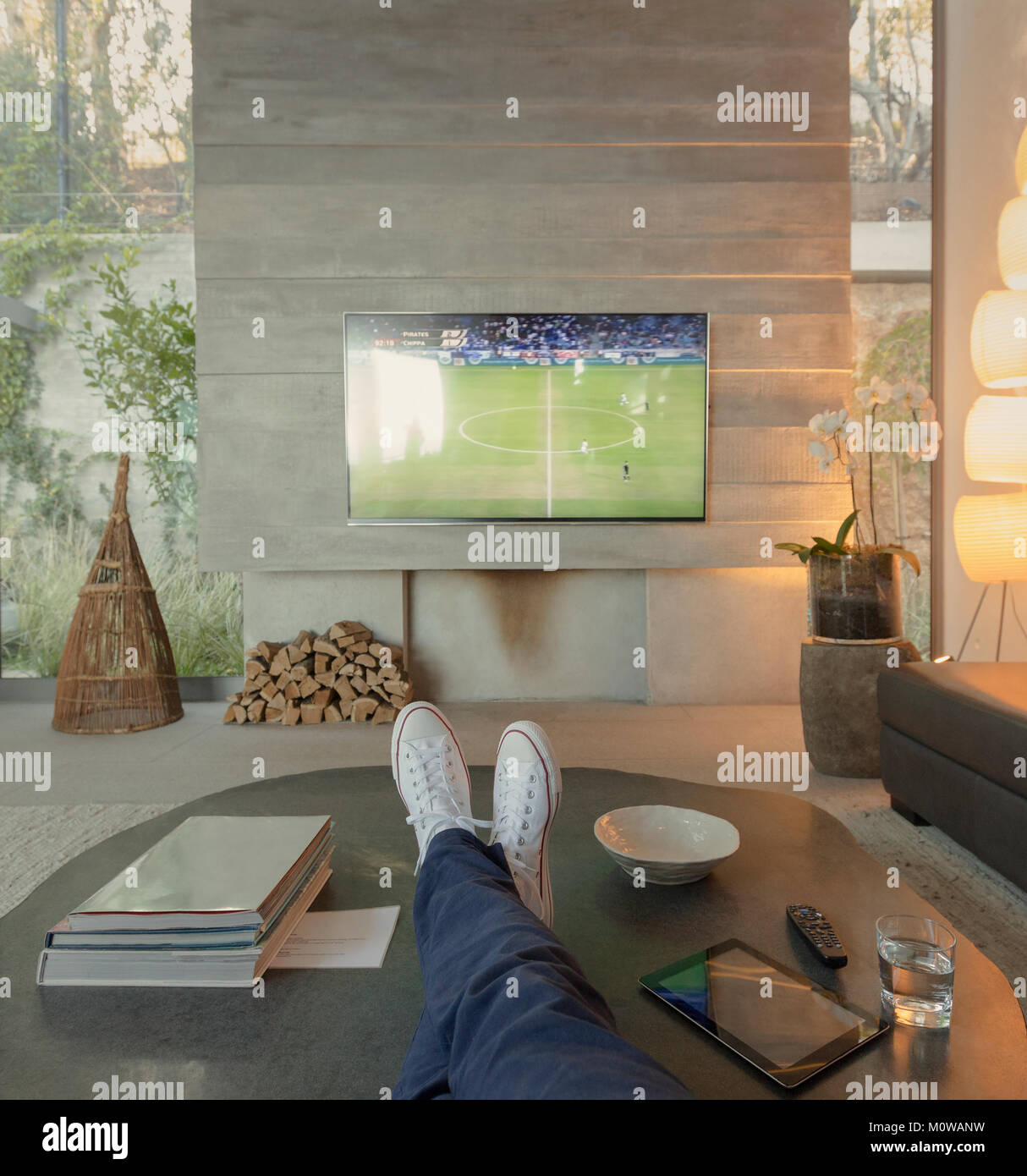 Persönliche Perspektive Frau Fußball Ansehen auf dem Fernseher im Wohnzimmer Stockfoto