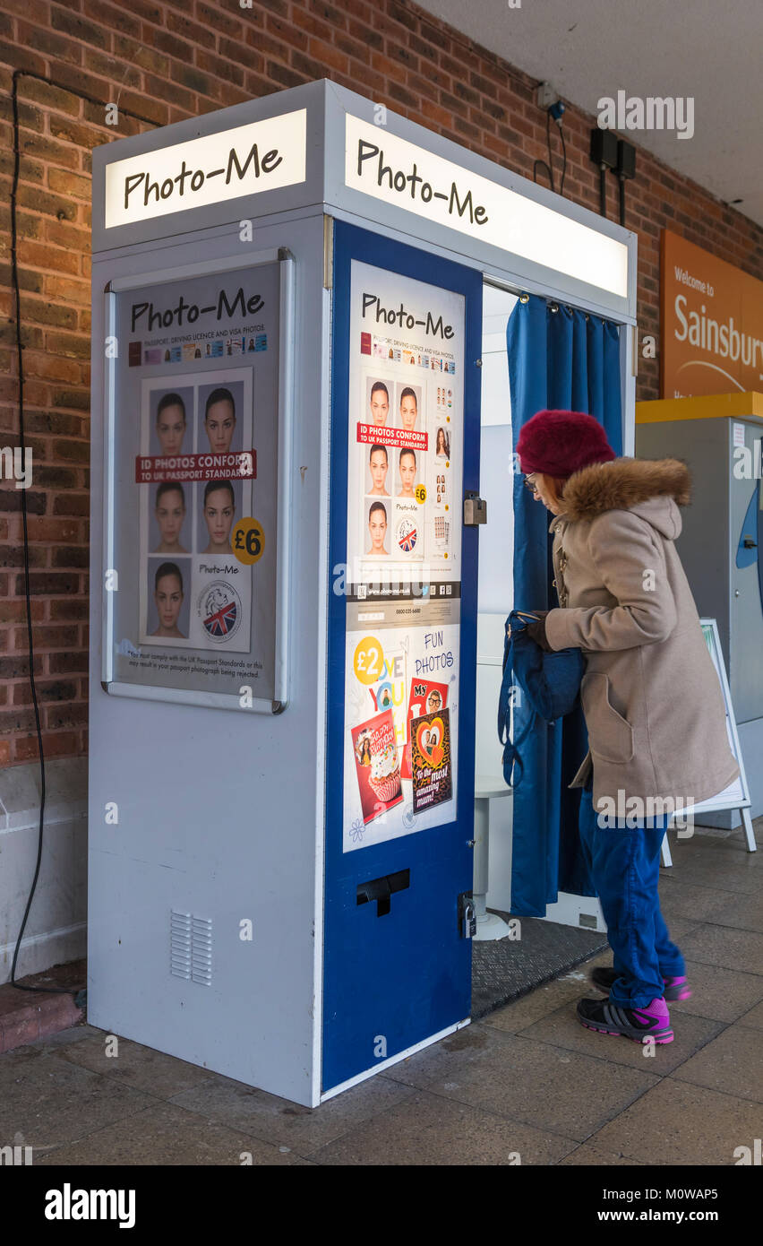 Frau gehen in einen Photo-Me Passport Photo Booth in Großbritannien. Stockfoto