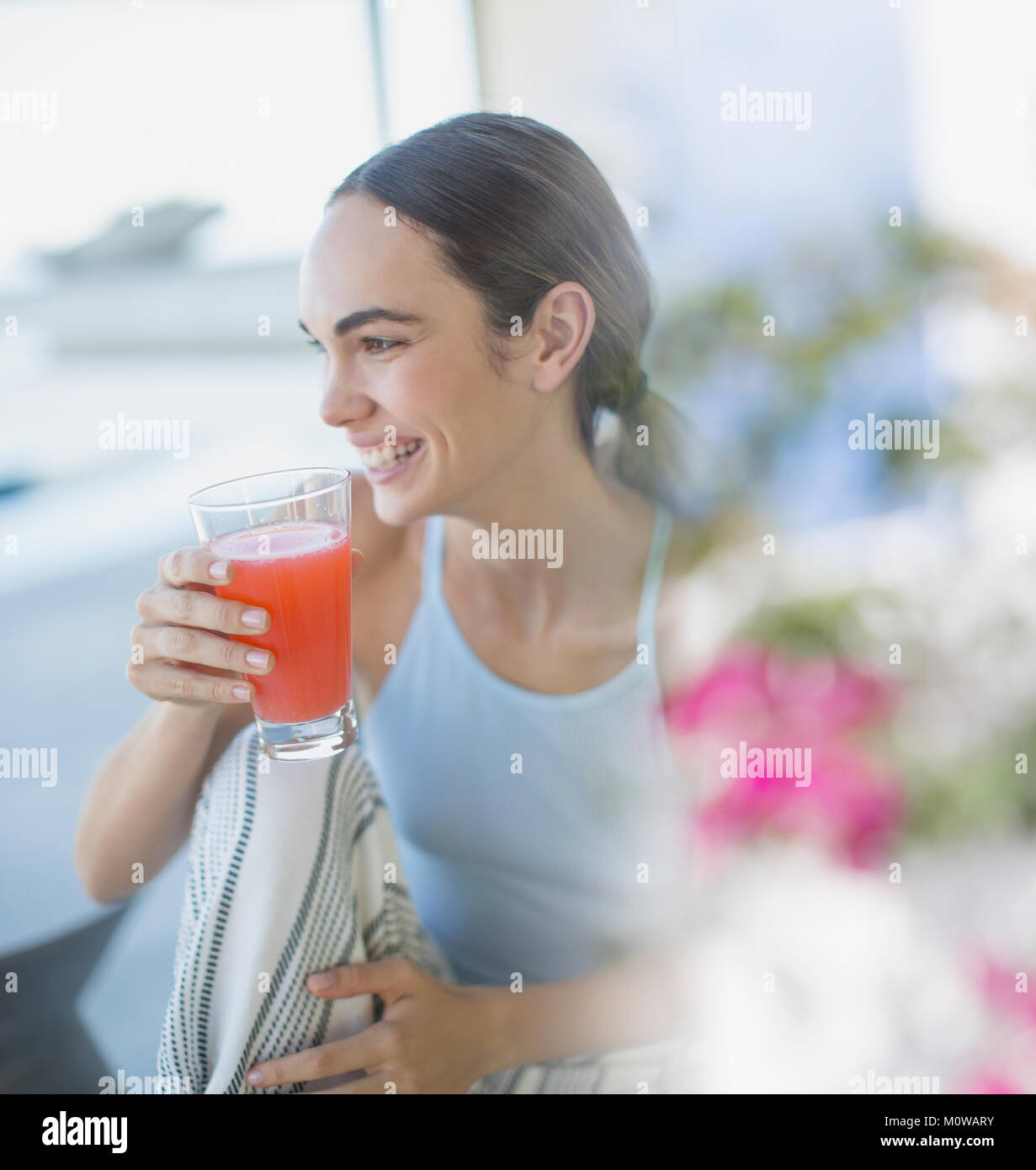 Lächelnd brünette Frau im Schlafanzug Saft trinken Stockfoto