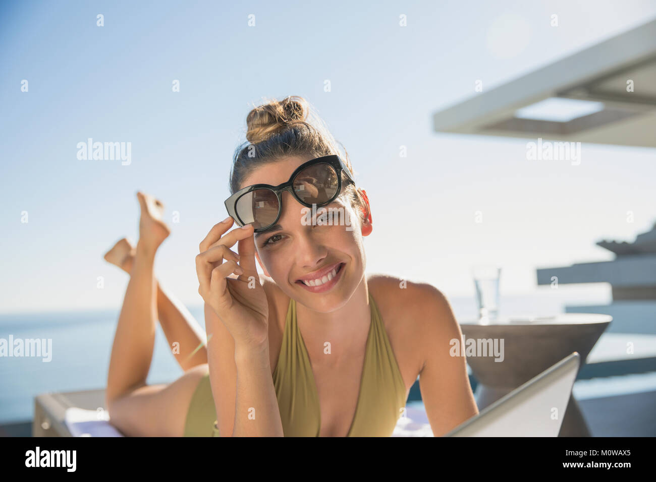 Porträt Lächeln, selbstbewusste Frau Sonnenbaden auf der sonnigen Terrasse Stockfoto