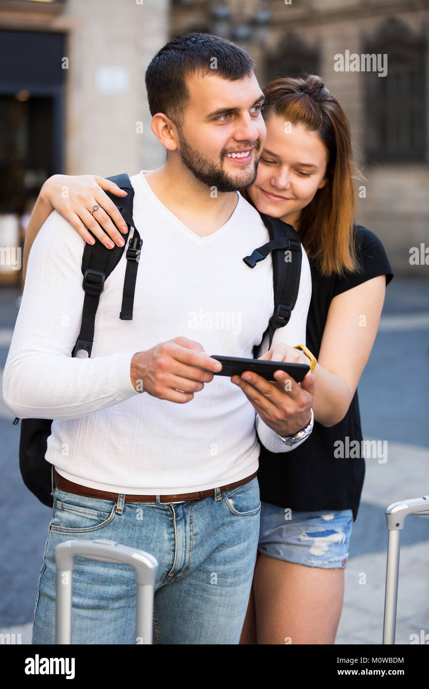Lächelnden jungen weiblichen und männlichen Touristen am Handy suchen zusammen Stockfoto