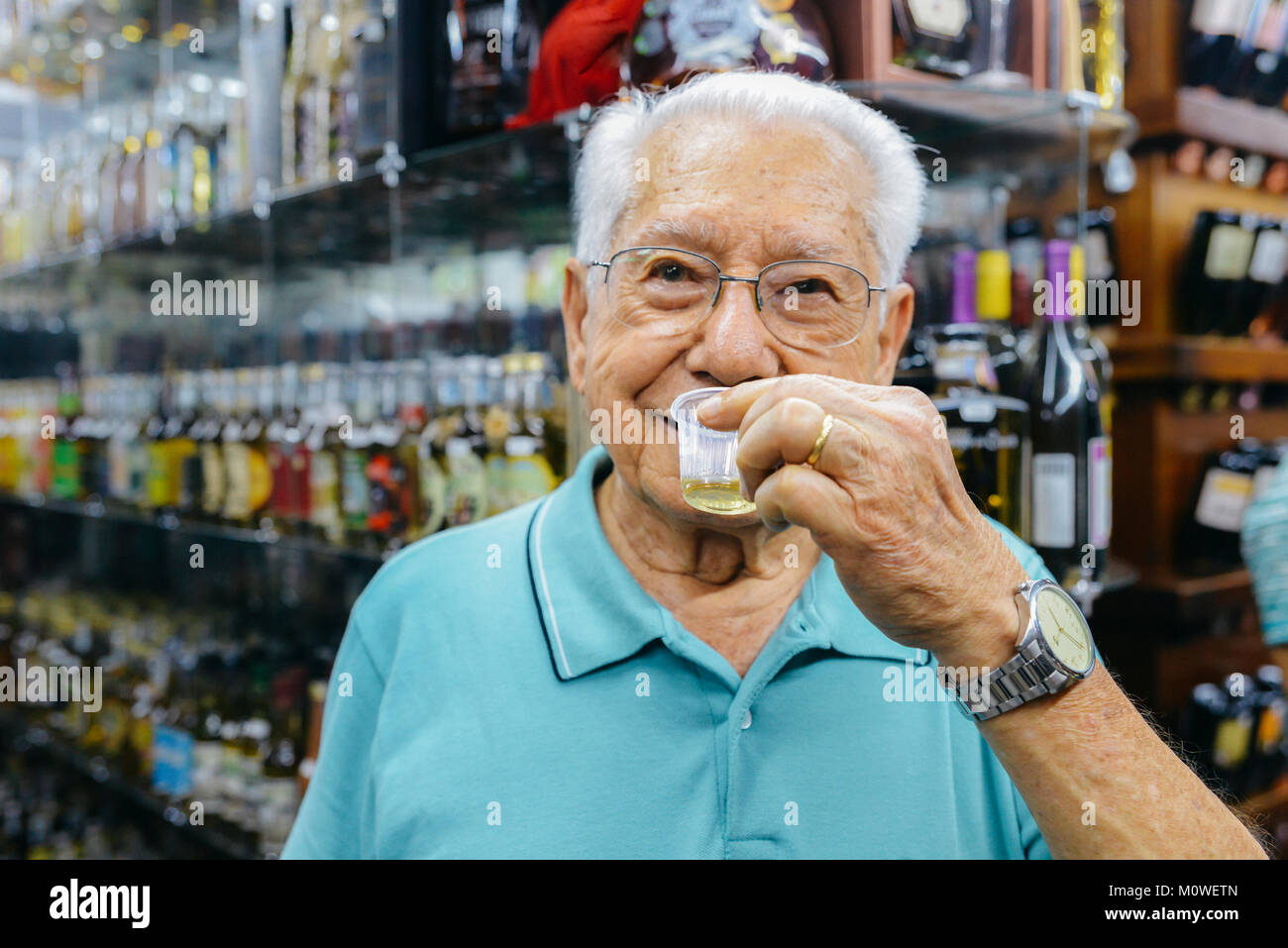Model Released: Ältere Menschen 80 bis 90 Proben eine Art von Cachaca Getränk, das aus Destillierten Zuckerrohr, Mercado Central in Belo Horizonte, MS, Brasilien Stockfoto