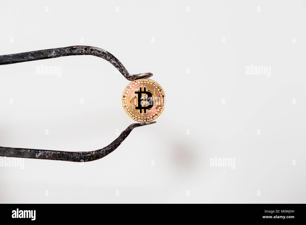 Bitcoin elektronische Münze Holding mit einem großen Bremssattel weißer Hintergrund Stockfoto