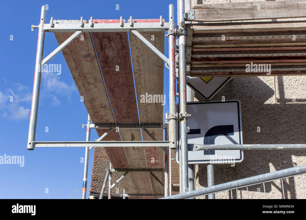 Detail eines Gerüsts mit straßenschild vor einem blauen Himmel Stockfoto