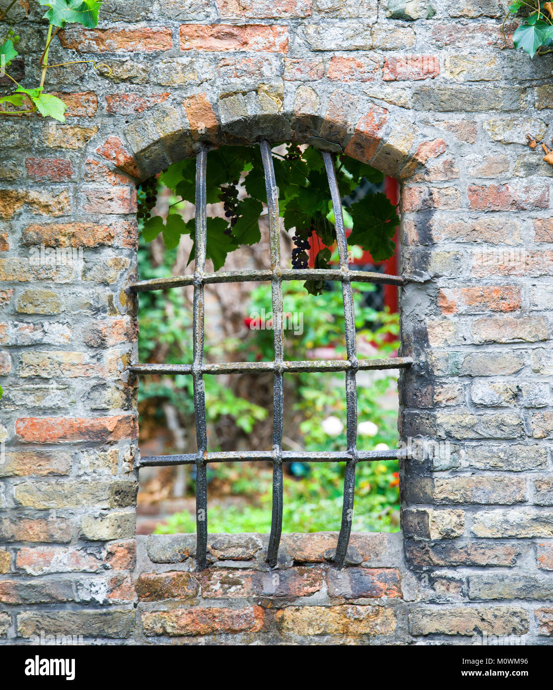Mittelalterliches Fenster mit eisernen Gitter in Brügge. Stockfoto