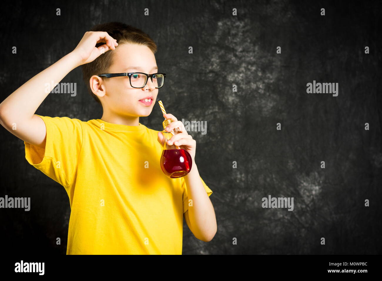 Teenager trinken Fruchtsaft tragen gelbe T-Shirt Stockfoto