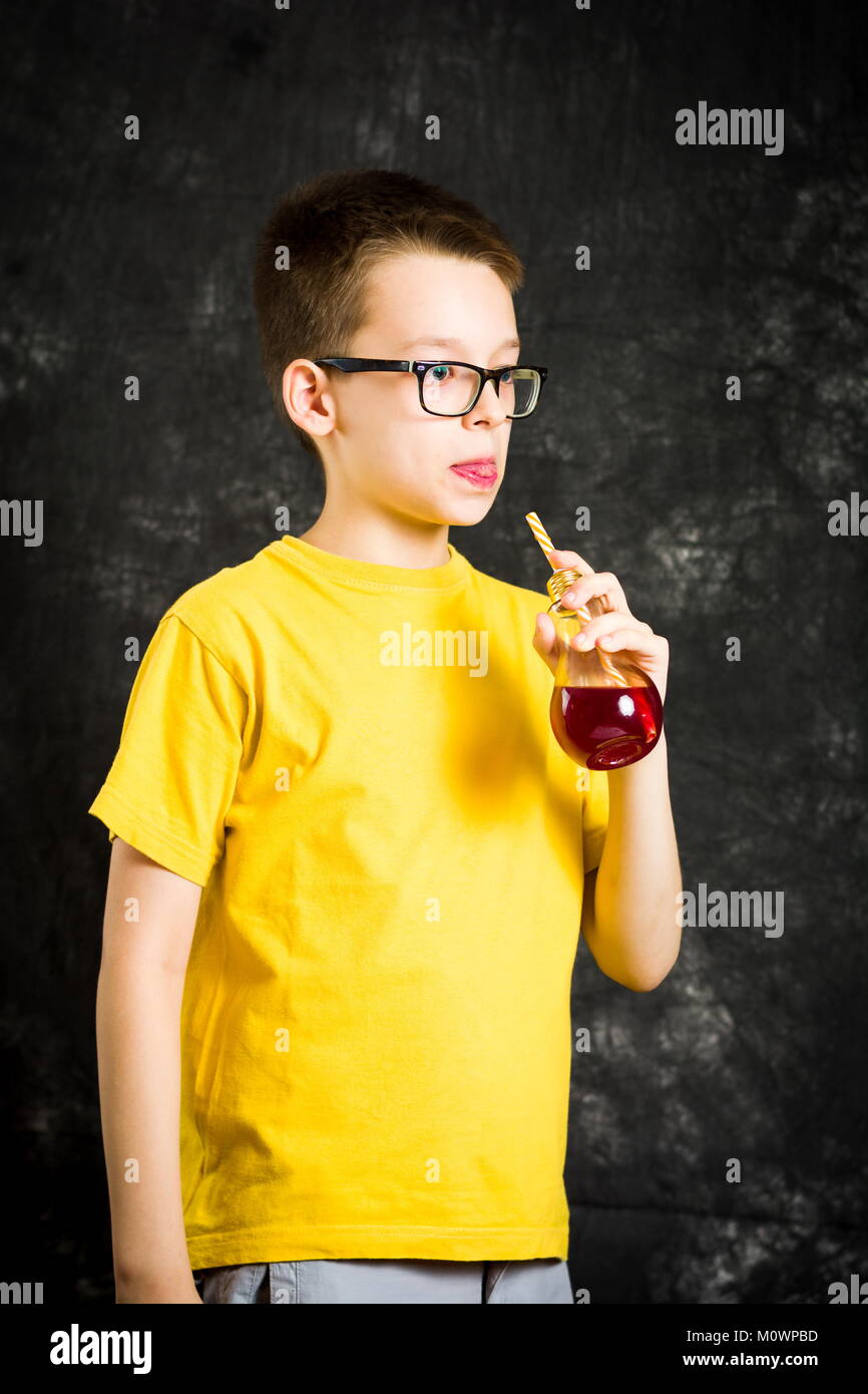 Teenager trinken Fruchtsaft tragen gelbe T-Shirt Stockfoto