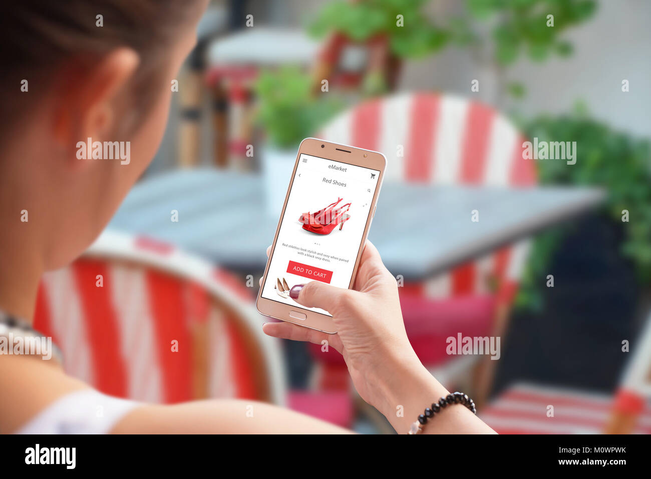 Online Einkaufen mit dem Handy. Rote Schuhe auf Store web site. Frau verwenden smart phone im Café oder Restaurant. Stockfoto