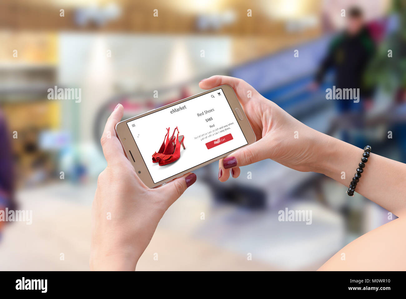 Einkaufen mit dem Handy. Frau mit smart phone in die horizontale Position. Shopping Mall im Hintergrund. Stockfoto