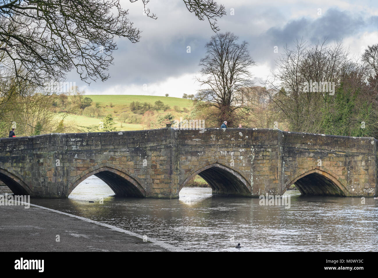 Steinbrücke über den Fluss Wye an einem kalten, sonnigen Winter an der Stadt von Bakewell im Peak District, Derbyshire, England. Stockfoto