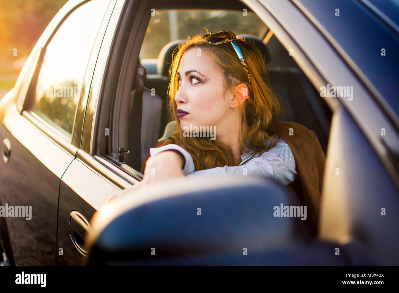 Elegante Frau auf einem Vordersitz eines Fahrzeugs Stockfoto