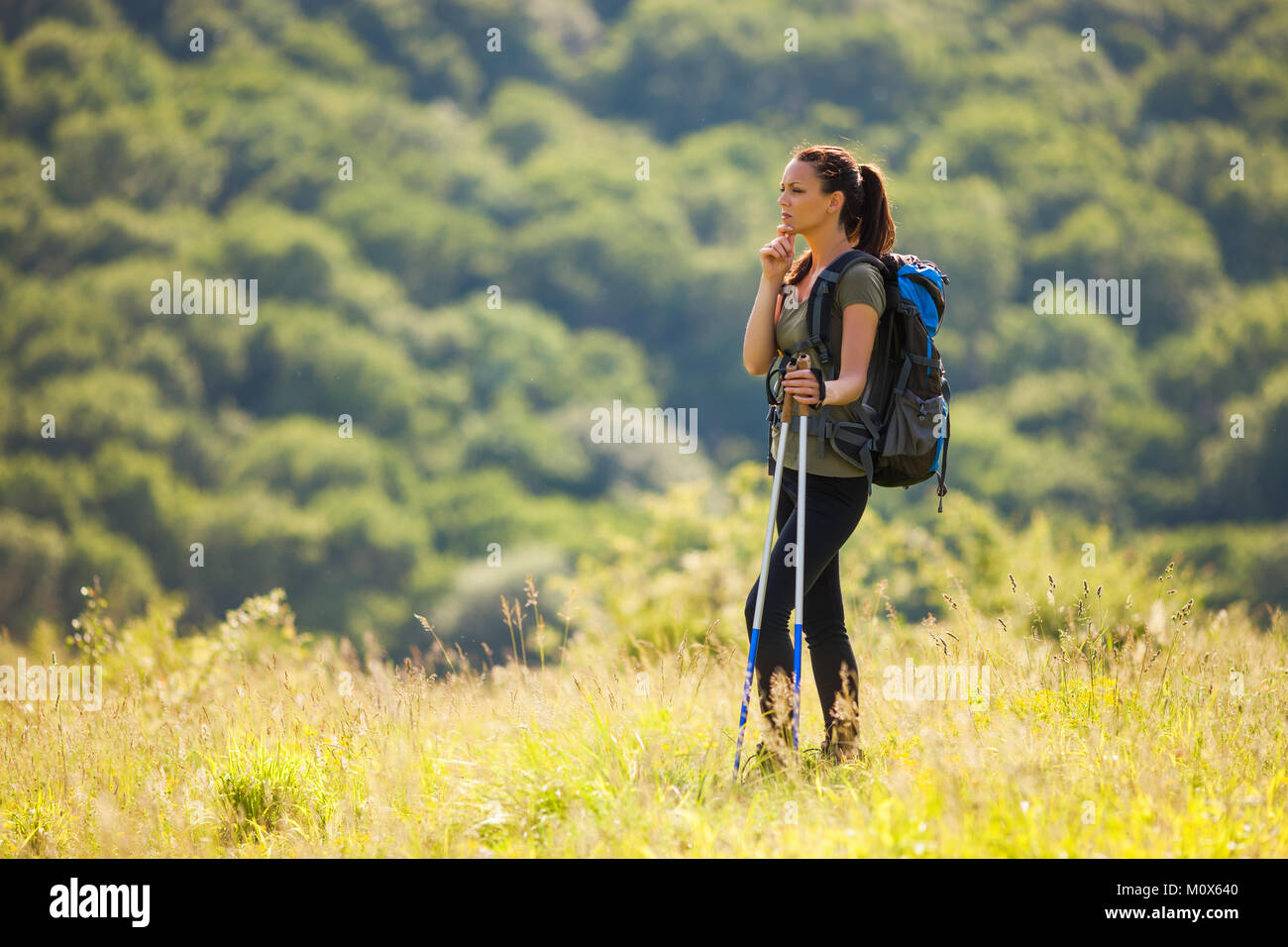 Junge Frau ist Wandern in den Bergen. Sie überlegt, einen Weg zu gehen. Stockfoto