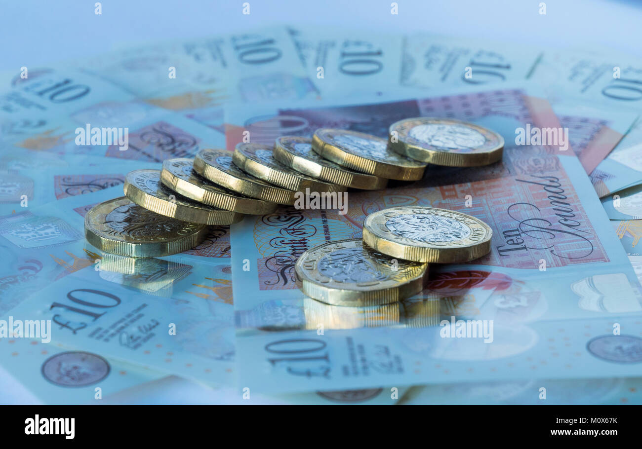 Mehrere Pfund Sterling Münzen liegen auf einem runden Bett der Neuen auf 10 Britische Pfund Noten Stockfoto