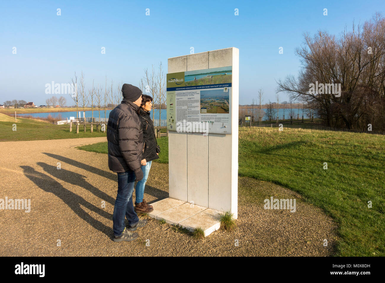 Paar lesen Information Board, River Park Maasvallei, Naturpark, Reserve, ehemaliger Kiesgewinnung, Teiche an der Maas, Limburg, Belgien. Stockfoto