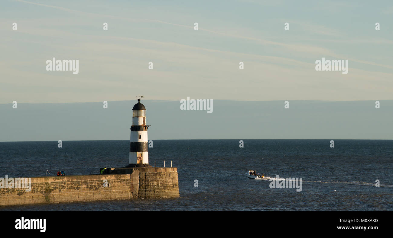 Kleines Boot, das Seaham Harbour verlässt, um Meer zu angeln, wobei der alte Leuchtturm gut zu sehen ist Stockfoto