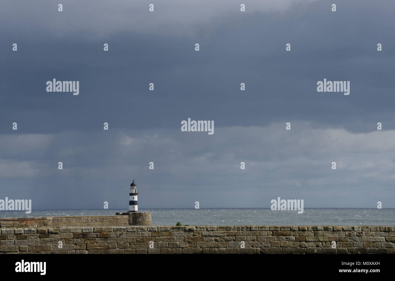 Der Leuchtturm von Seaham Harbour gegen einen dunklen Himmel an der britischen Nordostküste Stockfoto