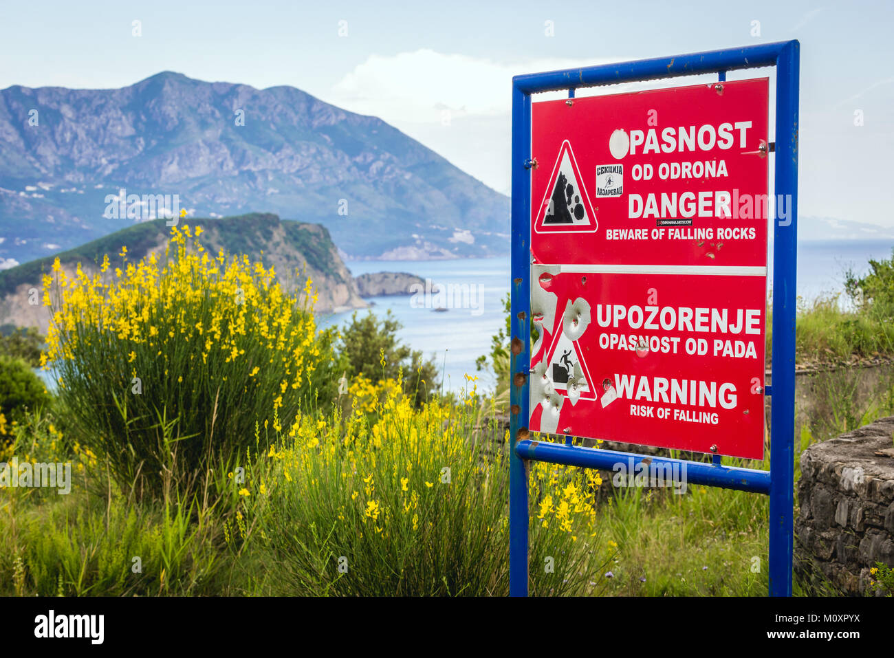Warnung neben Felsen und Ruinen aus dem 19. Jahrhundert österreichische Mogren Festung in Budva Stadt an der Adria Küste in Montenegro Stockfoto