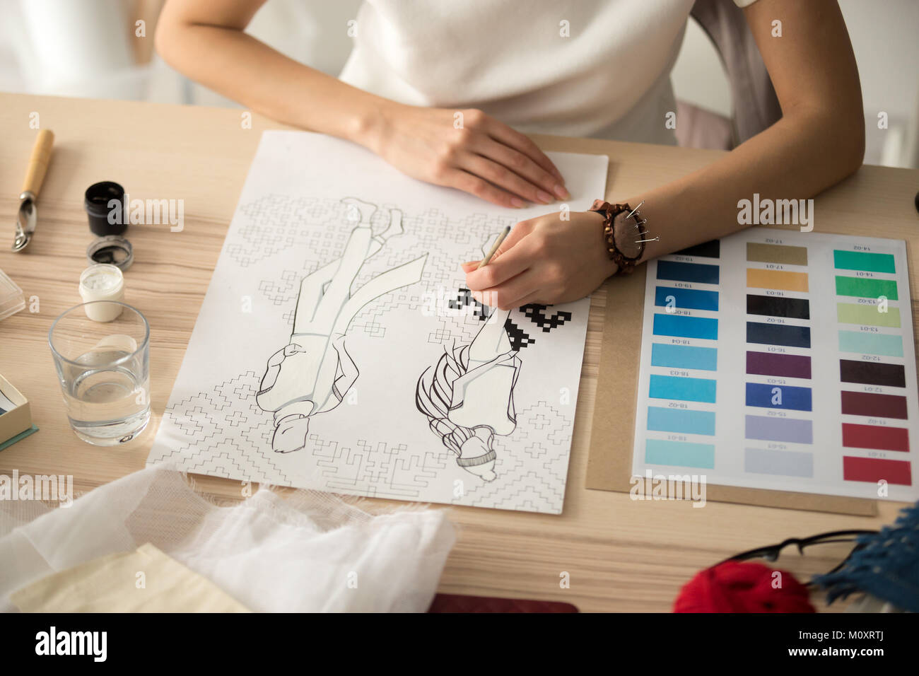 Weibliche designer Hände malen Stickmuster Regelung auf fash Stockfoto