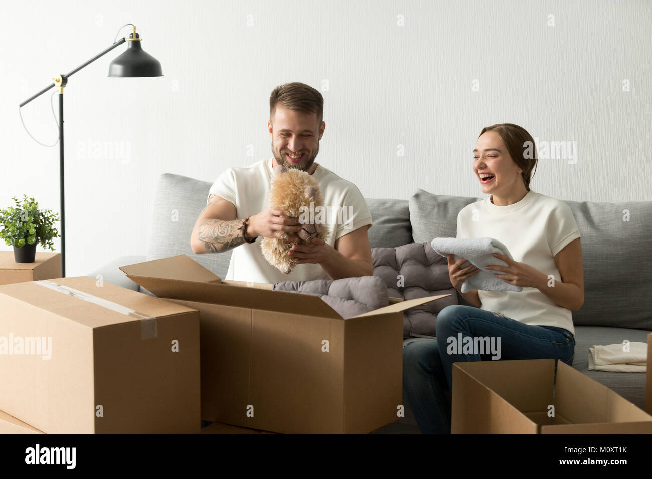 Lachen junges Paar, das Spaß, die Kisten packen, im neuen Haus Stockfoto