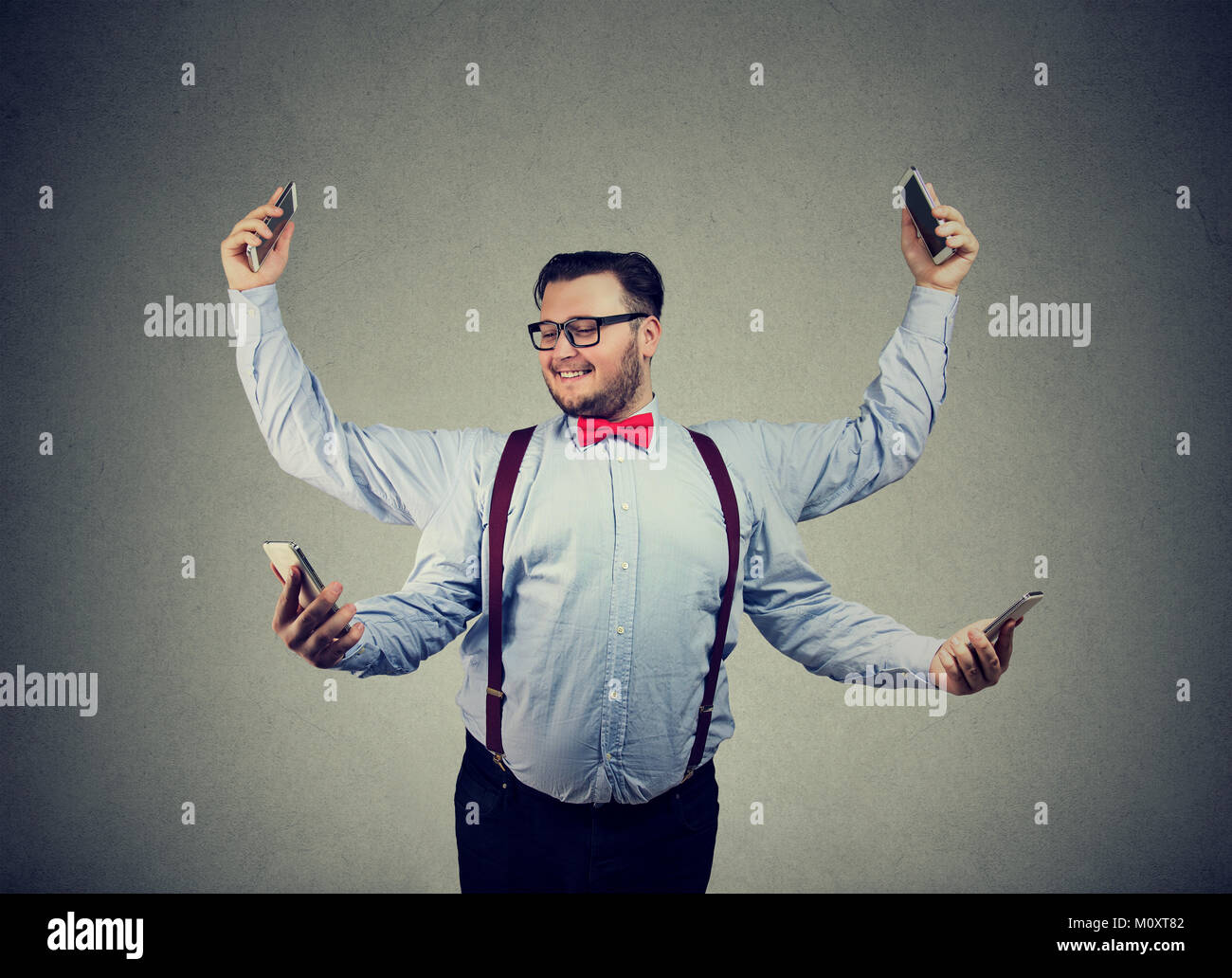 Chunky junger Mann in formelle Kleidung in vier Arme und mit Smartphones, Multitasking. Stockfoto