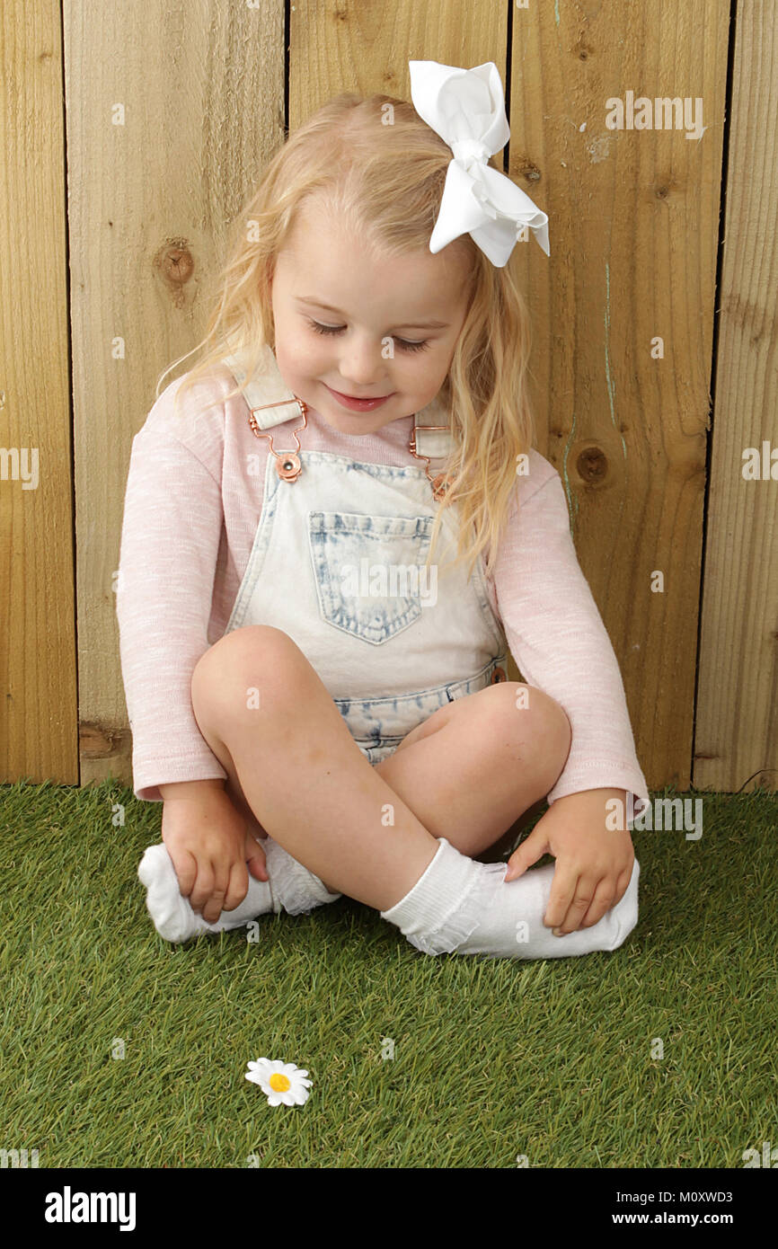 Schüchternes kleines Mädchen, 3 Jahre altes Mädchen beim Spielen im Garten  Stockfotografie - Alamy