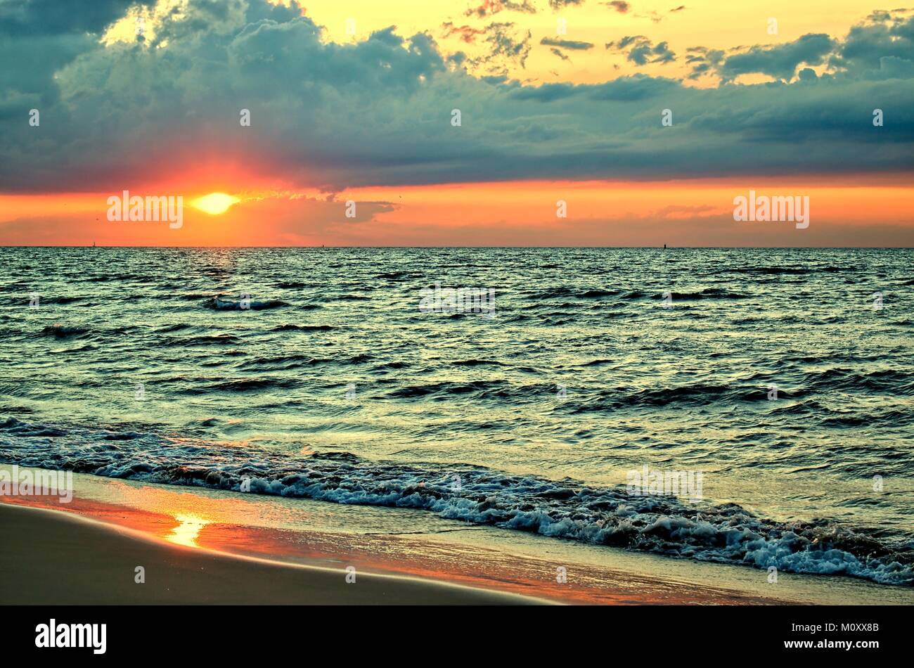 Strand, Sommer, Entspannung und Ruhe Konzept-malerischen und schönen Sonnenuntergang auf dem Meer und dunkle Wolken über der Nordsee. Stockfoto