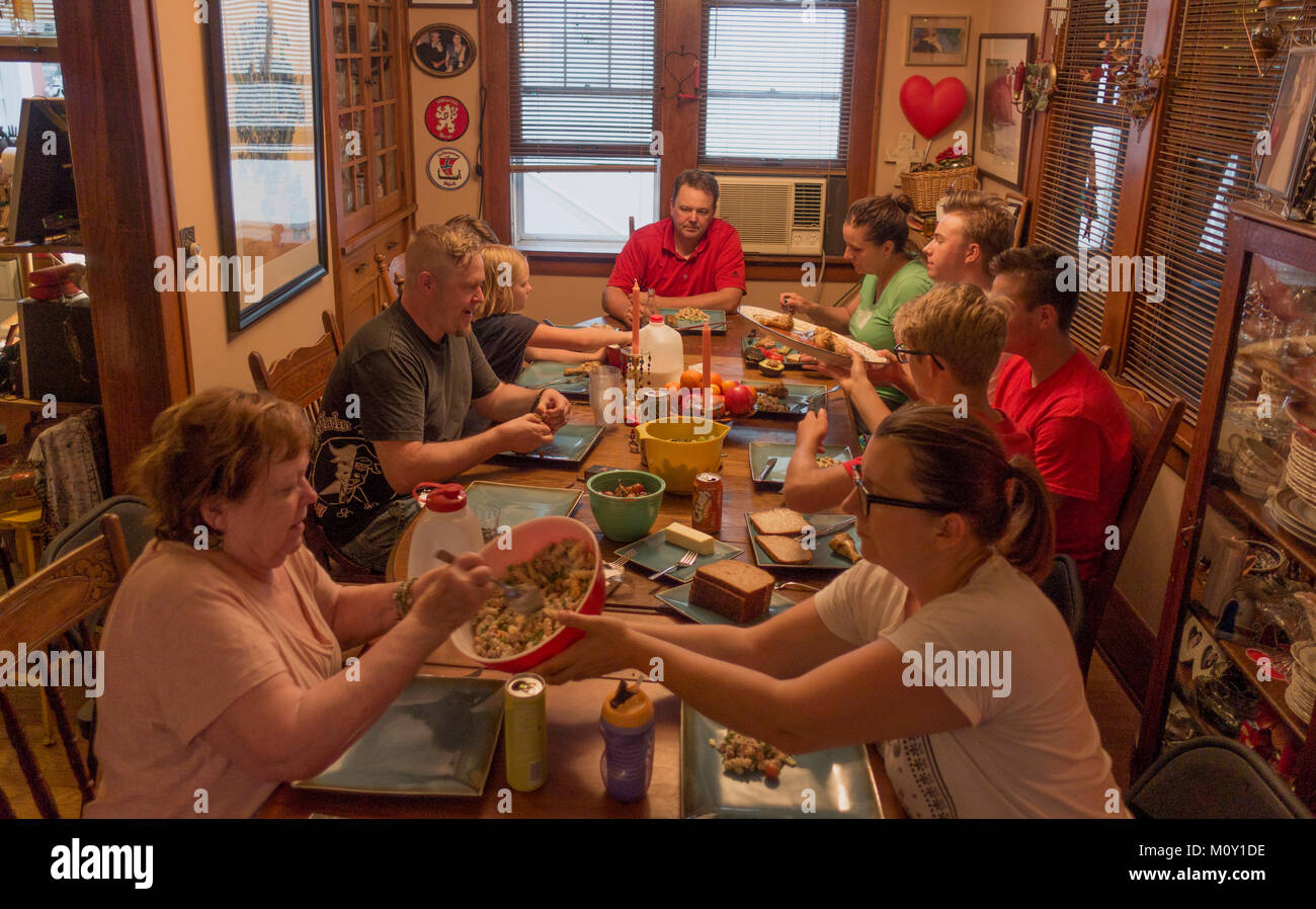 Erweiterte Familie von drei Generationen beim Abendessen zusammen an einem langen Tisch. St. Paul Minnesota MN USA Stockfoto