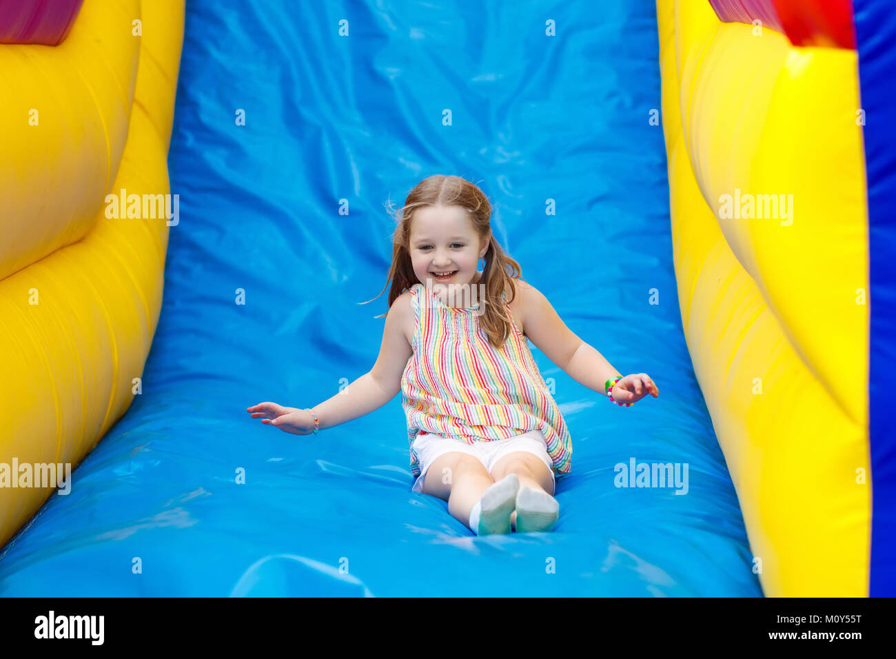 Kind springen auf bunten Spielplatz Trampolin. Kinder springen in Aufblasbare bounce Burg auf Kindergarten Geburtstag Aktivität und spielen Mitte für Sie Stockfoto