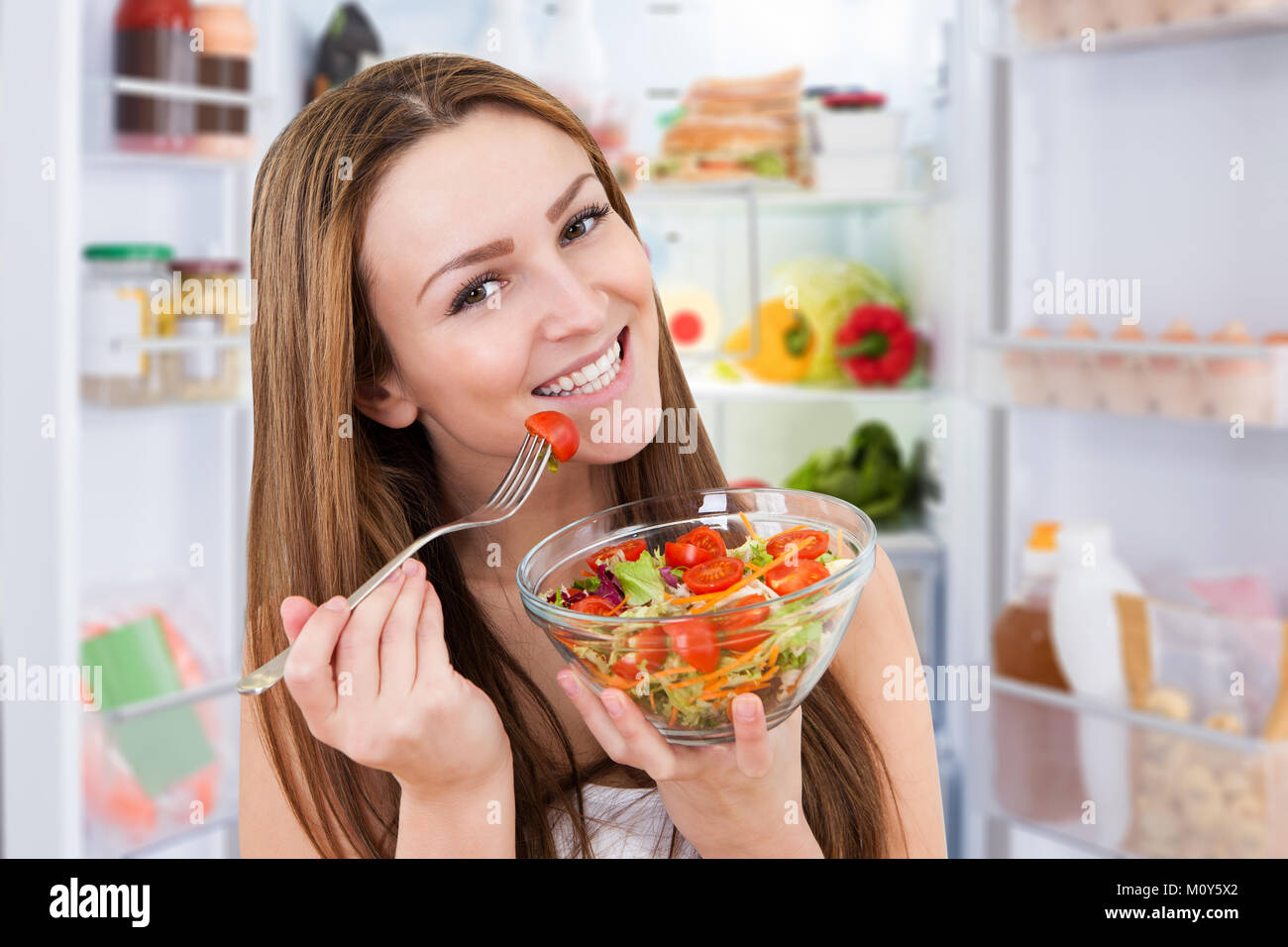 Portrait der junge lächelnde Frau das Essen von frischem gesunden Salat Stockfoto
