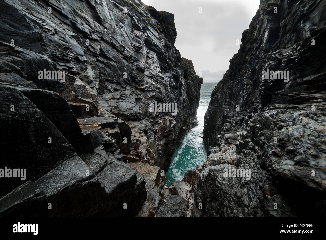 Hells Bohrung, eine unterirdische Höhle, in die die Atlantic tide explodiert mit einem enormen Kraft, Malin Head, Donegal, Irland. Stockfoto